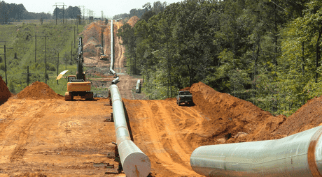 Image of a pipeline being constructed through a wooded field